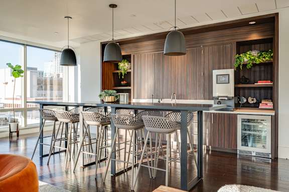 A modern kitchen with a bar area and chairs.
