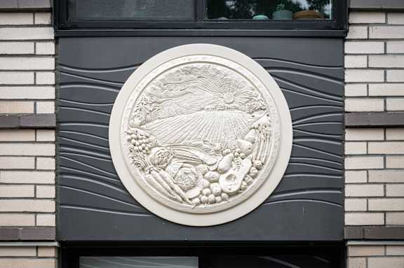 A circular relief sculpture on a building's facade.