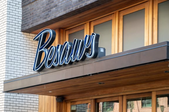 a neon sign for a beauty salon on the side of a building