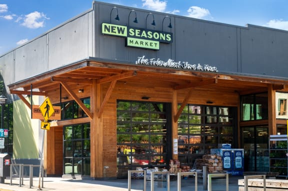 the front of a restaurant with tables outside of new seasons market