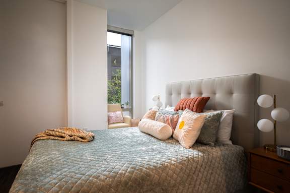 a bedroom with a bed and pillows and a window