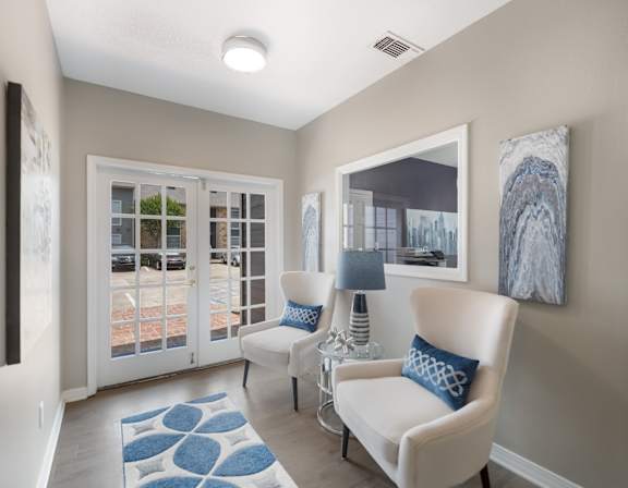 A living room with a white chair and a blue rug.