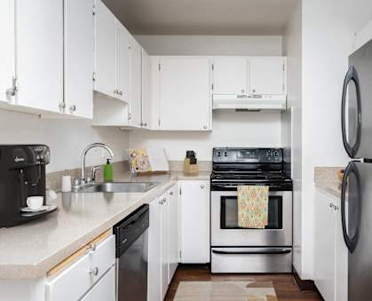 A kitchen with white cabinets and a stainless steel refrigerator.