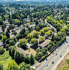 an aerial view of a neighborhood with cars on a highway