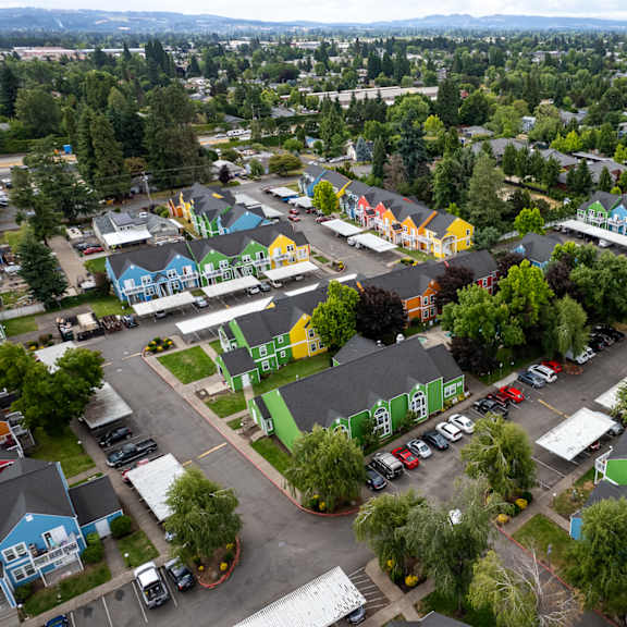 A colorful park with a playground and a parking lot.
