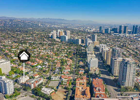 Exterior aerial view of an apartment building with cars parked.