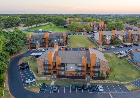 an aerial view of a campus with cars parked in a parking lot