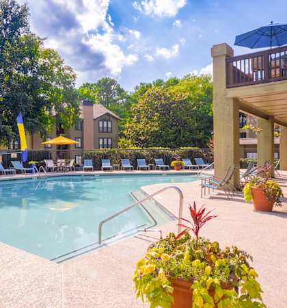 a swimming pool with lounge chairs and umbrellas at homewood suites by hilton