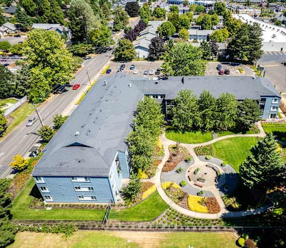 an aerial view of a building with a park in front of it