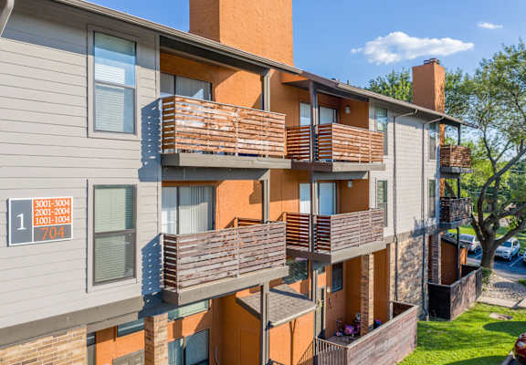 Apartment building with balconies and a sign that reads "2001-2004 704".