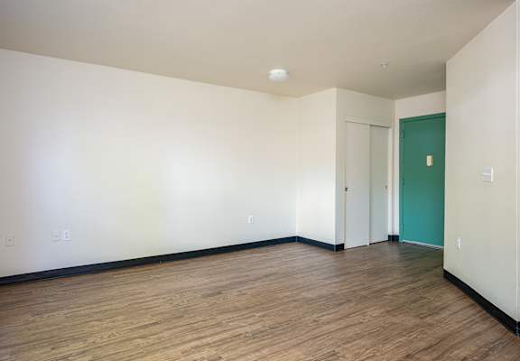 Empty room with wooden floor and white walls.