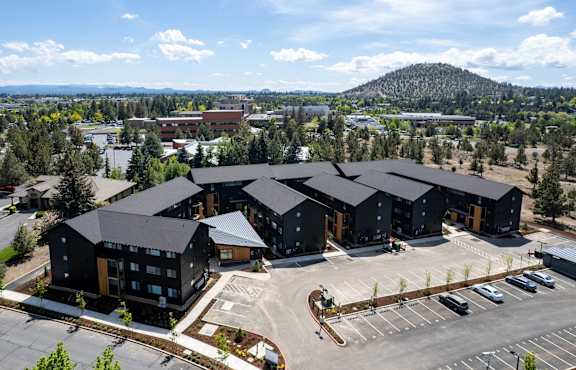 A large building complex with a parking lot in front.