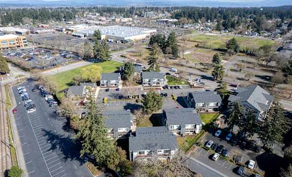 A bird's eye view of a parking lot with cars and buildings.