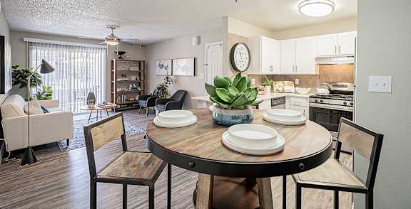 A dining room with a table set for two and a couch at Sterling Point Apartment Homes, Phoenix, AZ, 85042