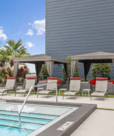Rectangular pool with lounge chairs by apartments at Bay Village 1 Apartment in Palmetto Bay, FL