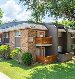 View of apartment building patios and balconies with wooden railing at Bayou Oaks Apartment Homes in Alexandria, LA