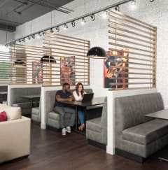 a couple sitting at a table in a room with couches and tables