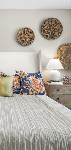 a bedroom with a large bed with white bedding and colorful pillows