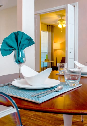 Lifestyle shot of dining room with a glasses and dinnerware at Chisholm Place Apartments in Plano, TX