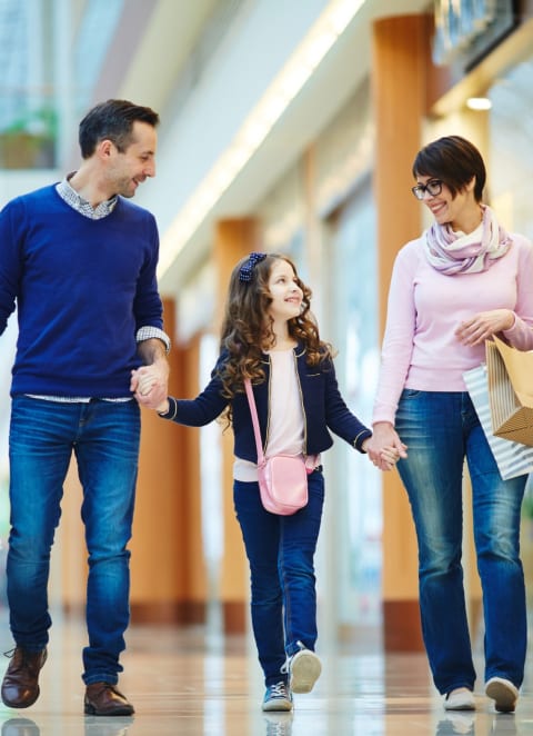 a family walking through a mall with shopping bags