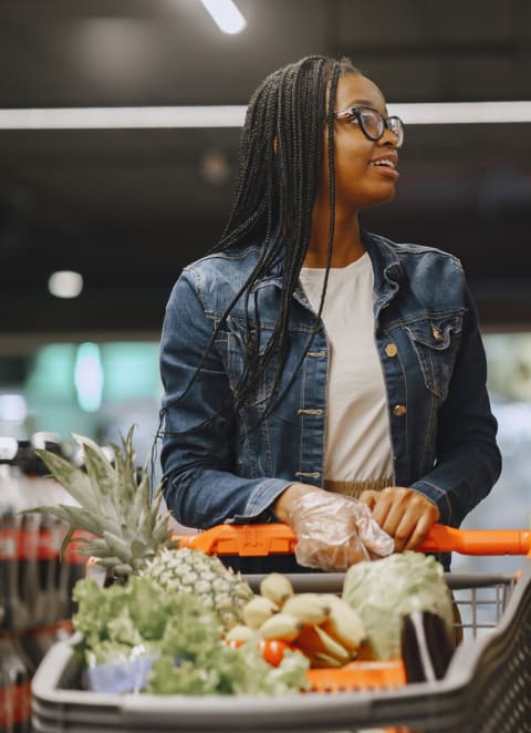 woman in a grocery store with a basket of vegetables