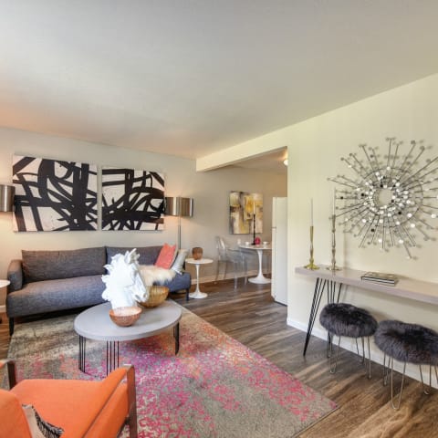 Living Room with Hardwood Inspired Floor, Orange Chairs, Lamps and Window  at Olympus Park Apartments, Roseville, CA, 95661