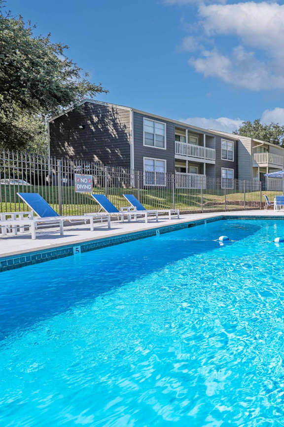 A large blue swimming pool with a white fence around it.