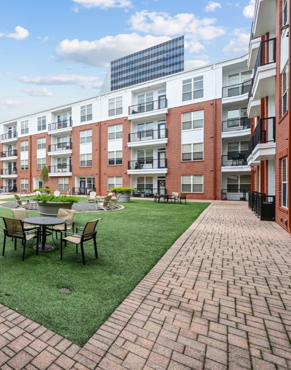 Outdoor courtyard with seating and landscaped gardens at The Grand at Upper Kirby apartments in Houston, TX