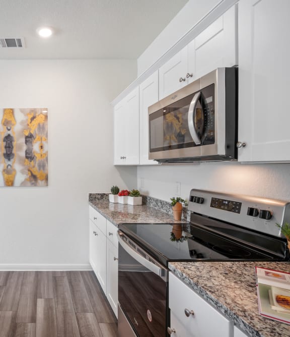 the heights on capitol hill apartments kitchen with granite countertops and stainless steel appliances at Beacon at Hymeadow, Maxwell, 78656
