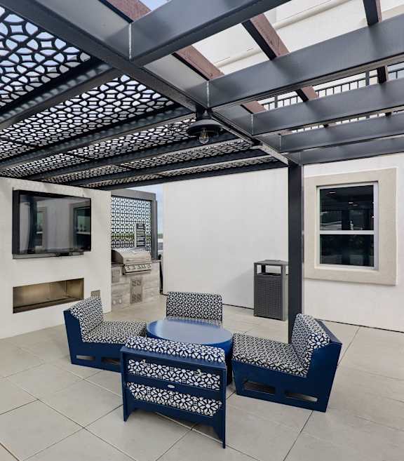 a rooftop deck with a bar and skyline in the background at Dominion Post Oak in Houston, TX