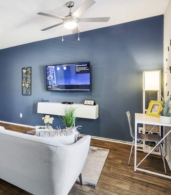 a living room with a blue accent wall and a white couch