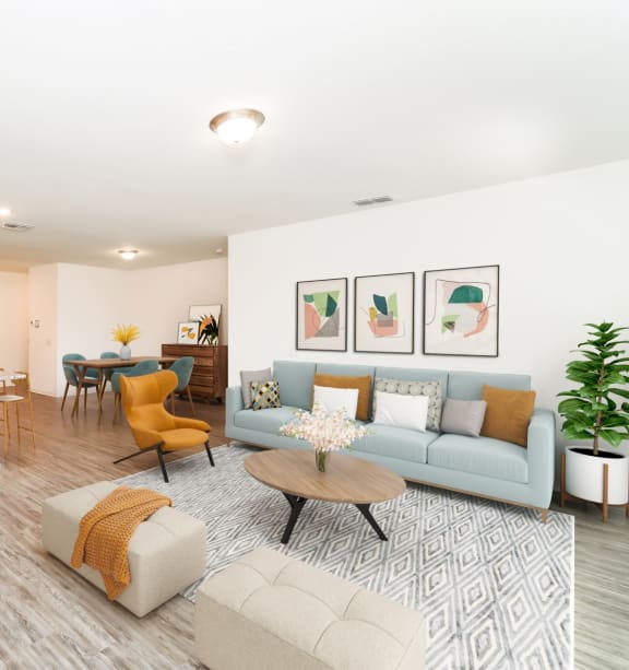a living room with contemporary furnitures, decors, white walls and hardwood flooring