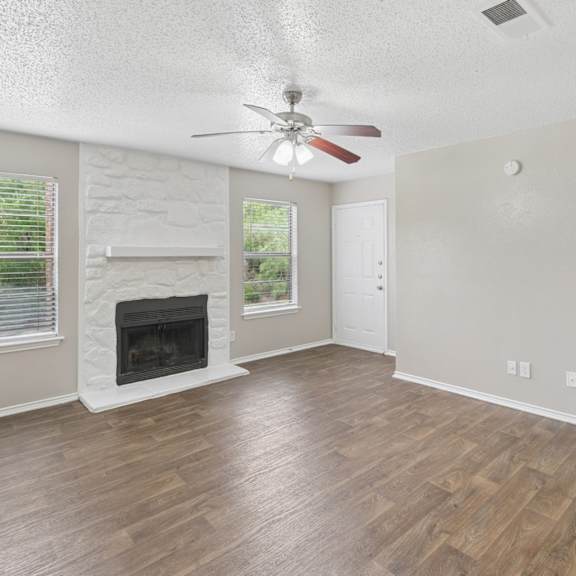 A room with a fireplace and a ceiling fan.