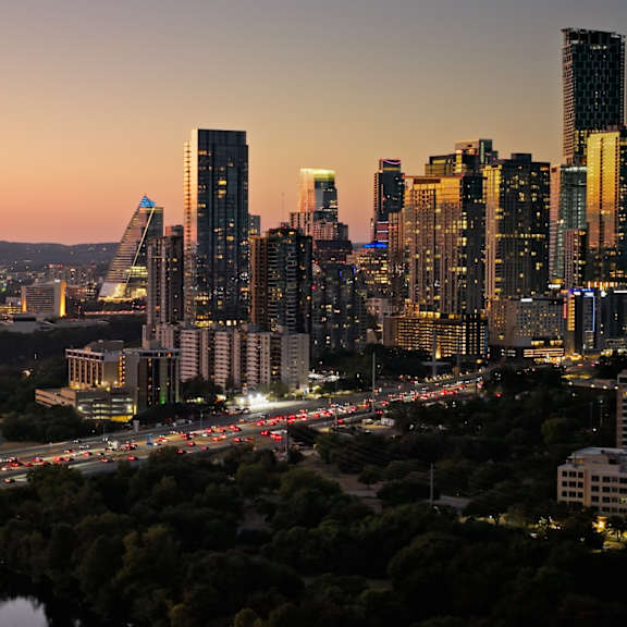 A cityscape at dusk with a river running through it.