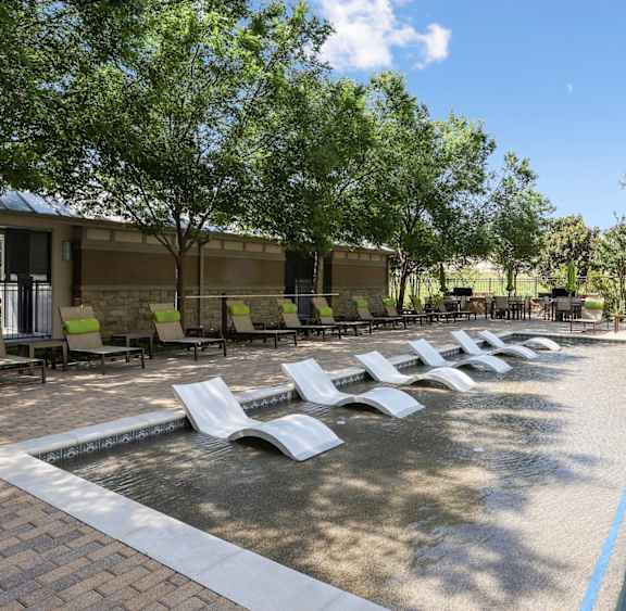 Our pool with in-pool lounge chairs at GreenVue apartments in Richardson, TX