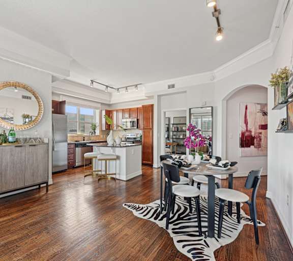 a kitchen and living room with hardwood floors and a large window at Dominion Post Oak in Houston, TX