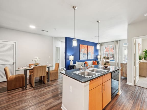 Open-concept living room and dining area with modern kitchen at The Grand at Upper Kirby apartments in Houston, TX