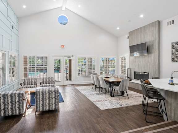 a dining room with a long wooden table and white chairs