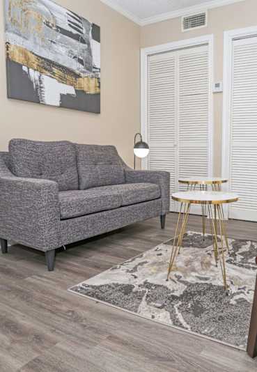 A room with a carpeted floor and a window with blinds.