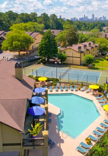 an aerial view of a resort style pool with lounge chairs and umbrellas