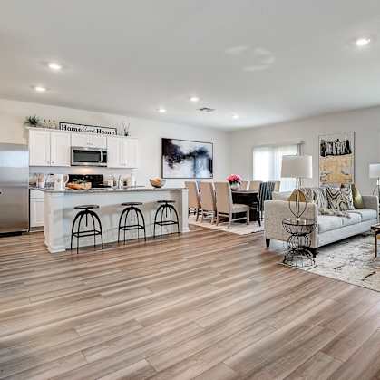 a spacious living room with a kitchen and a dining room