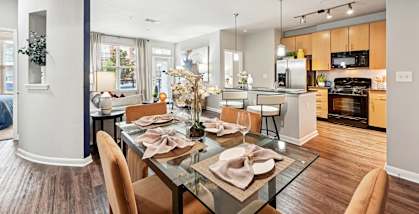 Stylish dining area and modern kitchen with pendant lighting at The Grand at Upper Kirby apartments in Houston, TX