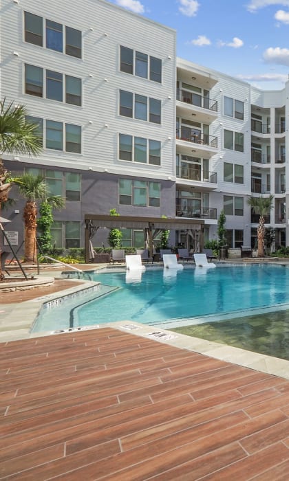 an image of a swimming pool in front of an apartment building
