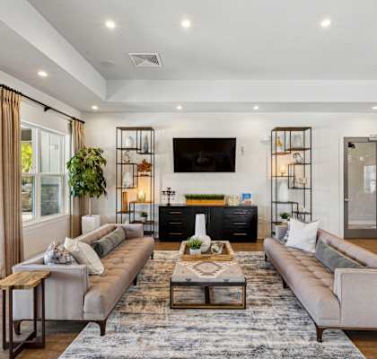 Lounge space in the leasing office with two couches and a television at Evergreen at Southwood in Tallahassee, FL