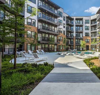 a courtyard with lounge chairs and tables at the bradley braddock road station apartments