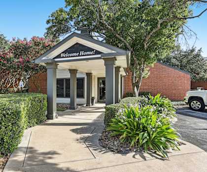 Leasing office entrance with beautiful foliage at Hunters Chase in Austin, TX