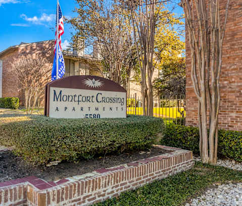 A sign for Montford Crossing apartments stands in front of a building.