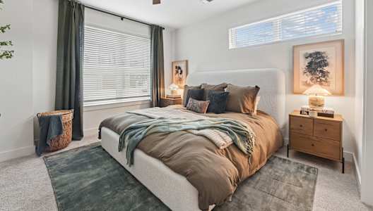 A bedroom with a large bed and a ceiling fan.