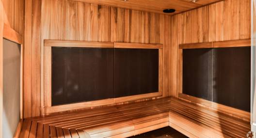 A wooden sauna with benches and doors.