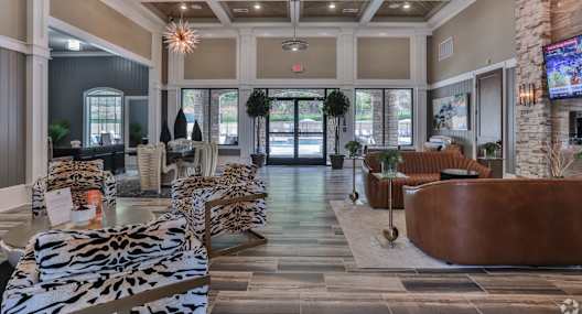 A large room with leopard print chairs and a stone wall.